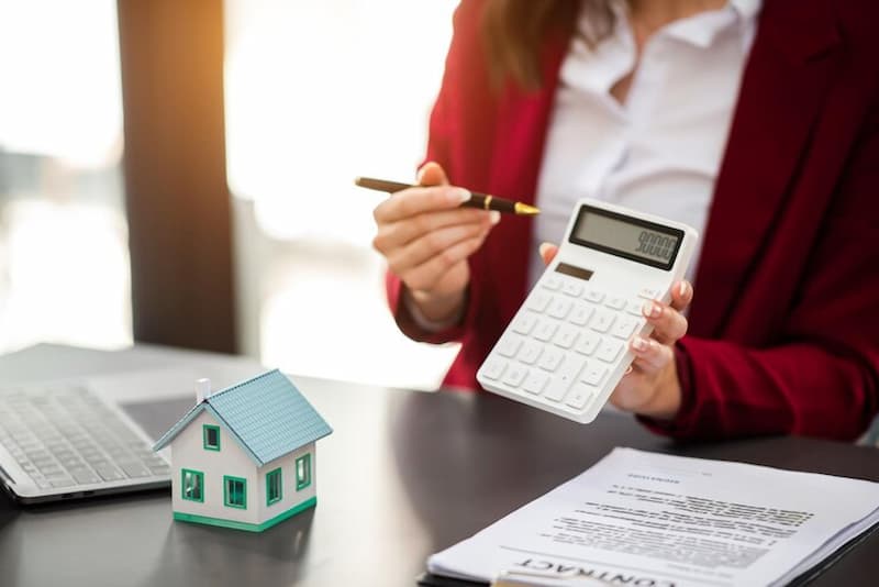 agente haciendo cálculos para minimizar costos fiscales al vender una casa