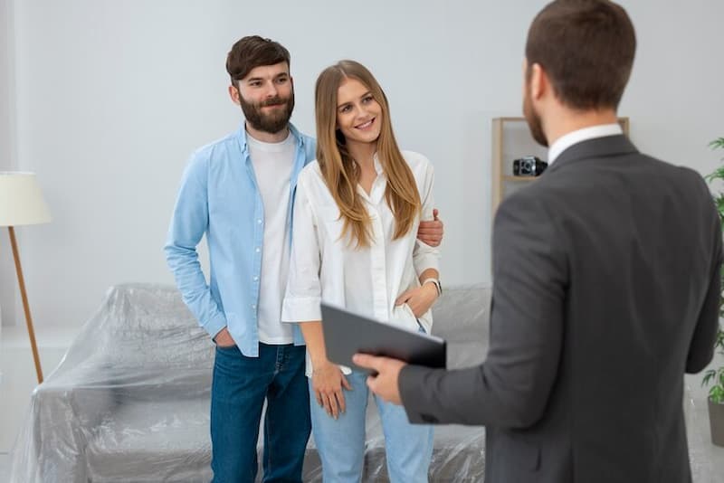 Hombre vendiendo casa a pareja joven