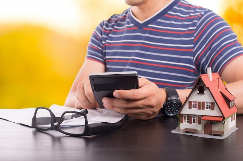 Hombre calculando impuestos en la compra de vivienda de segunda mano